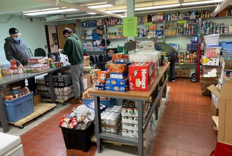 View of Food pantry - shelves with food. People wearing face masks.