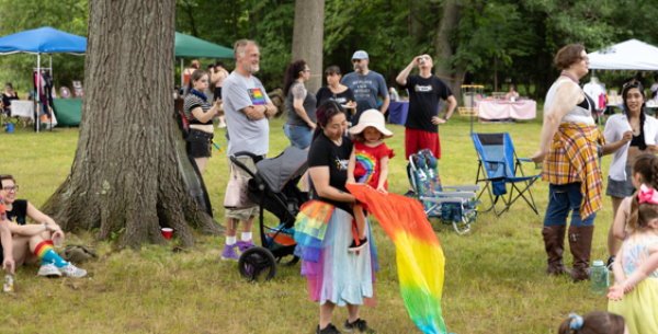 People in rainbow regalia watch a performance.