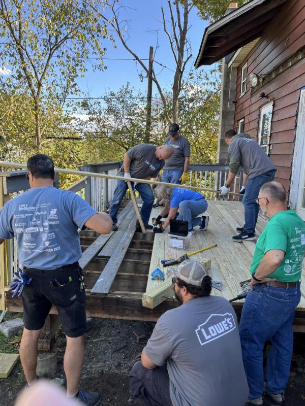 Volunteers work to rebuild a porch.