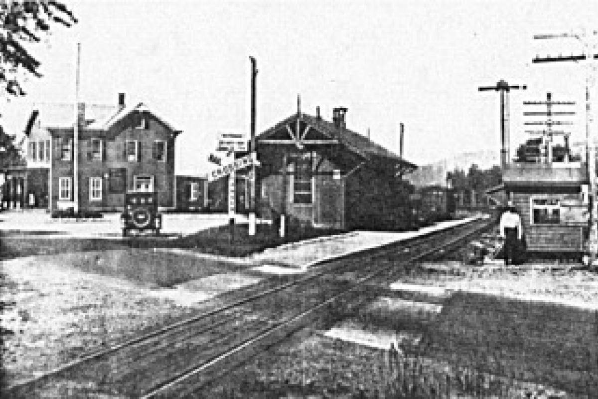 Life in simpler times. Here seen is the old Oakland railroad station in the late 1920s. Notice the man standing next to the small building. He was the Crossing Guard who manually lowered and raised the barrier to protect cars from crossing trains. However, his hours were limited from 7:00 AM to 4:00 PM.